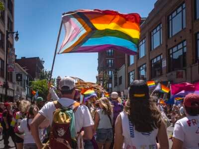 The Progress Pride Flag flies above a crowd during the Pride parade in Portland, Maine, on June 15, 2024.