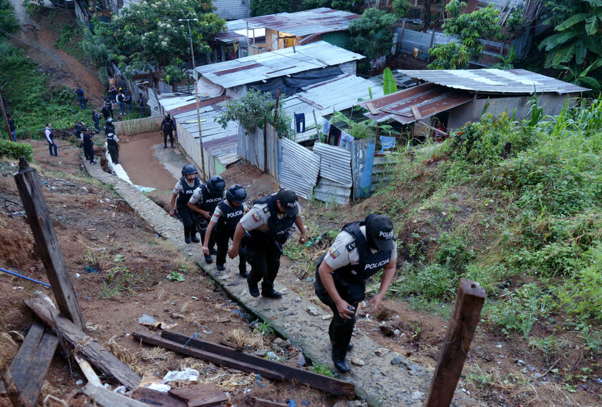 Police march through a shantytown