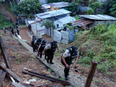 Police march through a shantytown