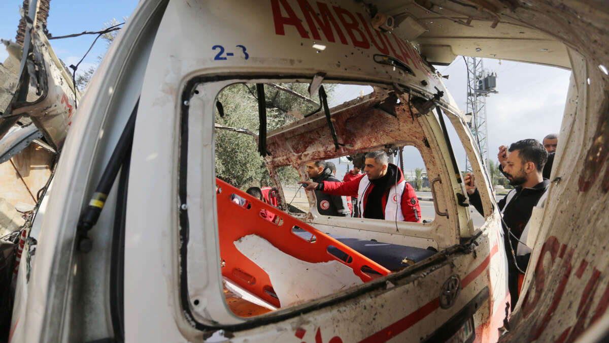 Medical personnel inspect the wreckage of an ambulance after the Israeli army's attack in Deir al-Balah, Gaza, on January 11, 2024.