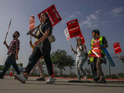 Amazon warehouse workers and members of Teamsters Union protest Amazons unfair labor practices and shameful response to workers demands for better, safer jobs with fair wages and an end to retaliation at Amazon Air Hub on October 14, 2022, in San Bernardino, California.