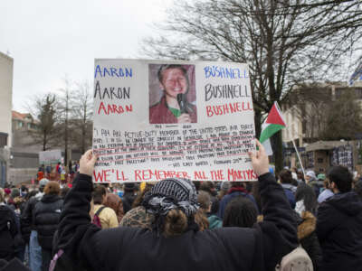 A demonstrator holds a sign with Aaron Bushnell's portrait and his last words written on it during the Global Days of Action for Palestine outside the Israeli Embassy on March 2, 2024, in Washington, D.C.