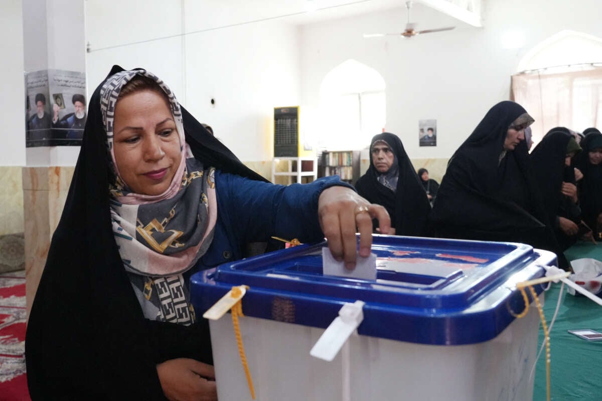 An Iranian woman casts her ballot at a polling station during the presidential election in Tehran, Iran, on June 28, 2024.