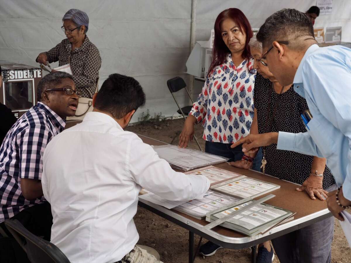 Poll workers and election scrutineers review the ballots before polls open in the Gustavo A. Madero borough of Mexico City on June 2, 2024.