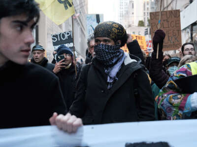 A protester wears a kuffeyeh during an outdoor protest against Cop City