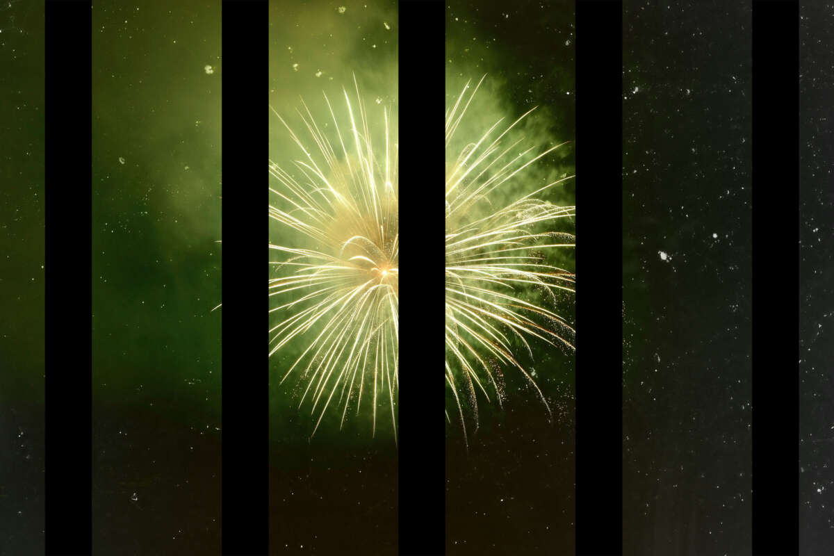 Green fireworks explode past dark black prison bars