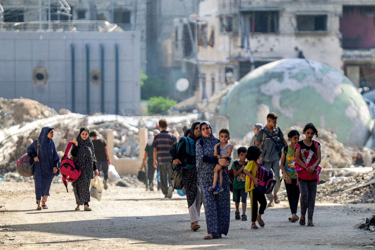 People walk past rubble and damaged buildings in the Tuffah district east of Gaza City on July 8, 2024.