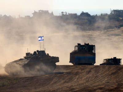 This picture taken from Israel's southern border with the Gaza Strip shows Israeli bulldozers behind an armored vehicle rolling along the border with the Palestinian territory on April 17, 2024.