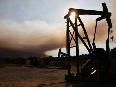 Oil pumpjacks operate as the Lake Fire burns in Los Padres National Forest on July 6, 2024, near Los Olivos, California.