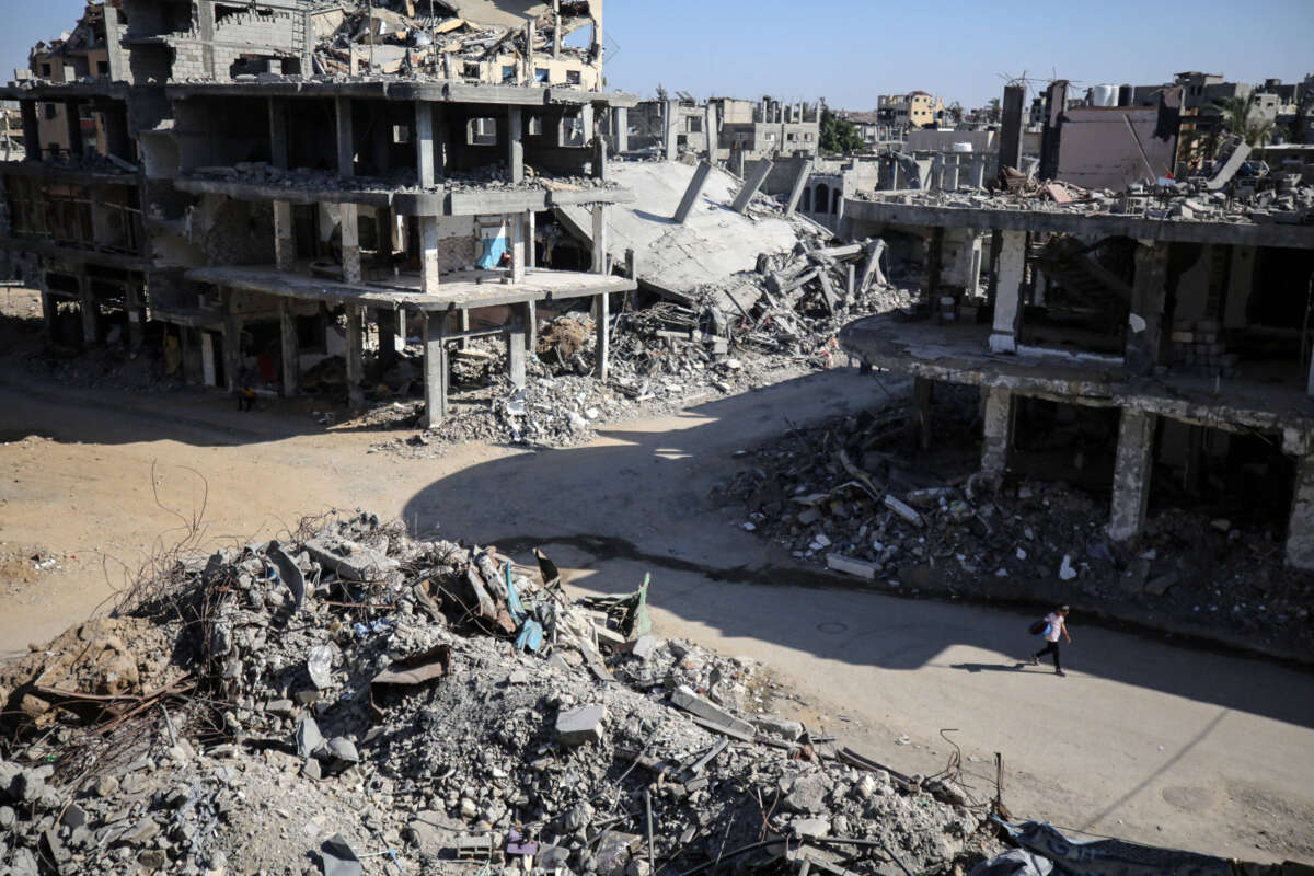 A youth walks along a road between the rubble of buildings destroyed during Israeli bombardment in Bureij camp in the central Gaza Strip, on June 24, 2024.