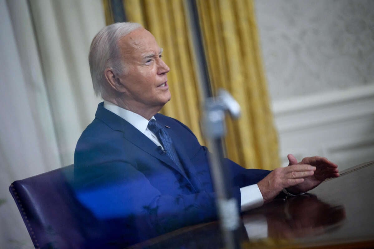 Seen through a window, President Joe Biden speaks during an address to the nation from the Oval Office of the White House in Washington, D.C., on July 14, 2024.
