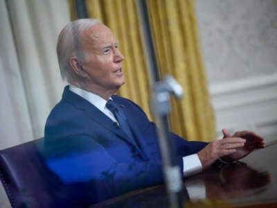 Seen through a window, President Joe Biden speaks during an address to the nation from the Oval Office of the White House in Washington, D.C., on July 14, 2024.