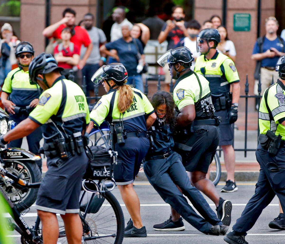 Cops drag a black-clad protester away