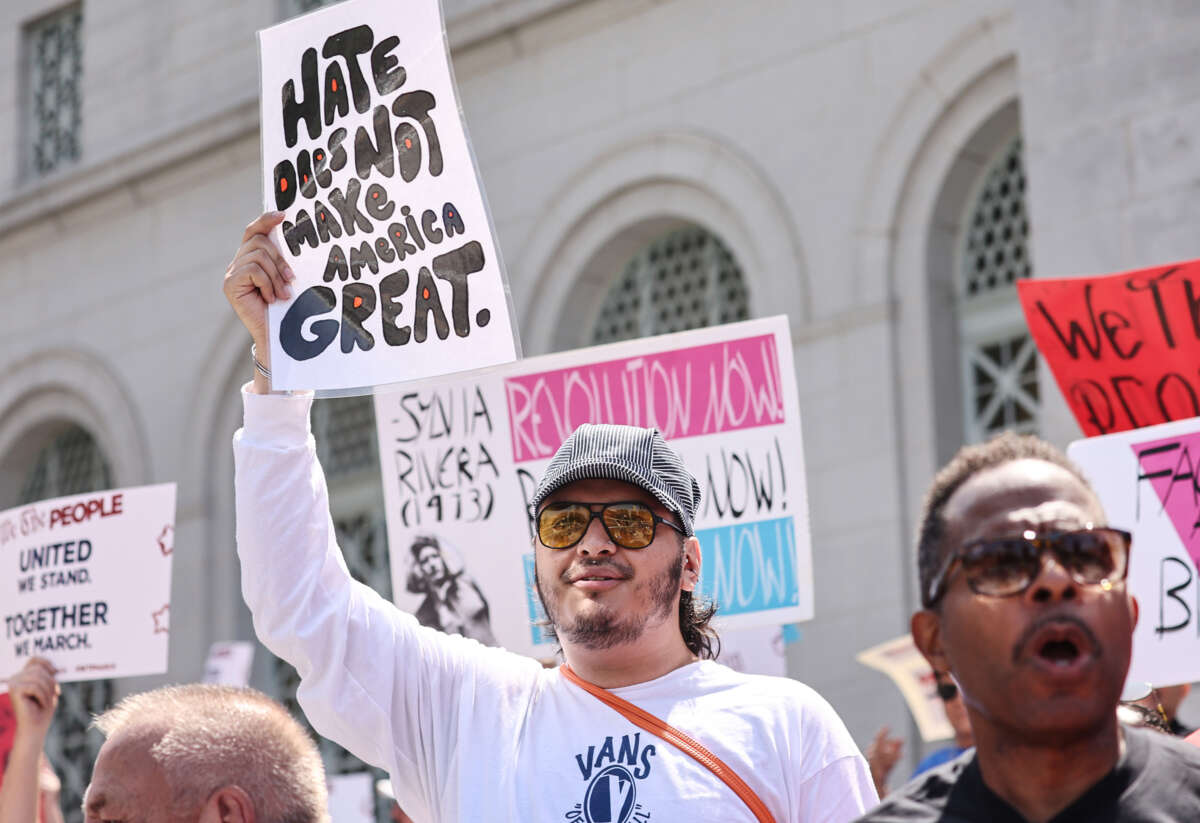 A protester holds a sign reading "hate does not make America great" during an outdoor protest