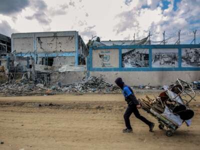 A man walks past the damaged Gaza City headquarters of the United Nations Relief and Works Agency for Palestine Refugees (UNRWA) on February 15, 2024. The building has since been leveled.