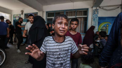 A Palestinian child cries after Israeli fighter jets hit a United Nations Relief and Works Agency for Palestine Refugees in the Near East (UNRWA) school, killing and injuring many in the Nuseirat refugee camp of Deir al-Balah, Gaza, on July 16, 2024.