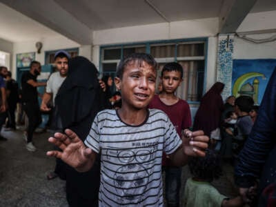 A Palestinian child cries after Israeli fighter jets hit a United Nations Relief and Works Agency for Palestine Refugees in the Near East (UNRWA) school, killing and injuring many in the Nuseirat refugee camp of Deir al-Balah, Gaza, on July 16, 2024.