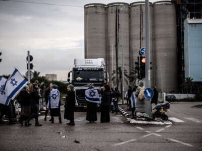 An activist settler group of dozens of people, holding Israeli flags, gather at the exit of Ashdod Port near the Gaza Strip and block trucks carrying aid to Gaza Strip, in Ashdod, Israel, on February 4, 2024.