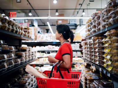 A woman shops in the pastry aisle of a grocery store