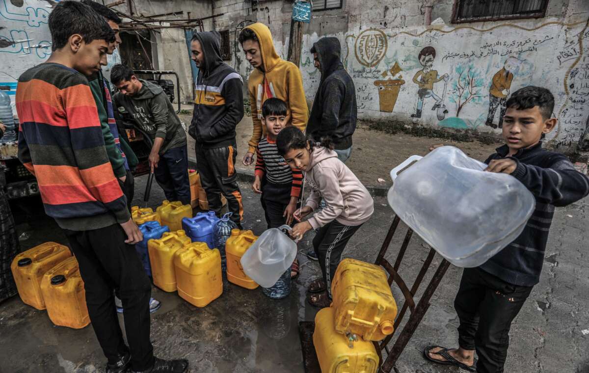 Palestinian children wait with jerry cans to fill them with drinking water in Rafah on February 19, 2024.