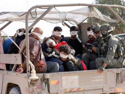 Israeli soldiers transfer detained Palestinians out of the Gaza Strip on November 21, 2023.