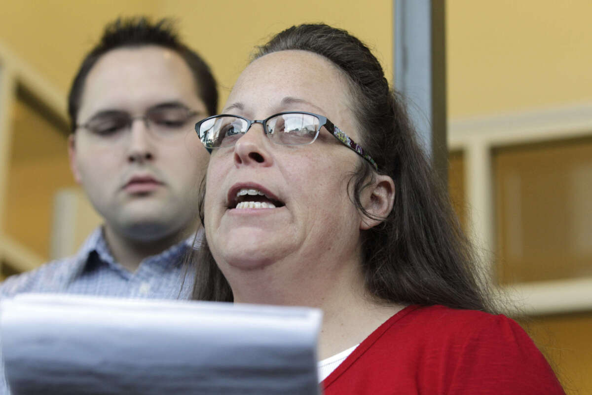 Rowan County Clerk Kim Davis, with son Nathan Davis, a deputy clerk, reads a statement to the press outside the Rowan County Courthouse on September 14, 2015, in Morehead, Kentucky.