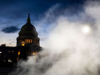 a view of the US capitol at night, as seen from behind a plume of smoke