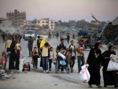 Palestinians, including children, evacuate the area with their belongings after the Israeli army announced an operation to be organized at the Bureij refugee camp in Deir al-Balah, Gaza, on July 28, 2024.