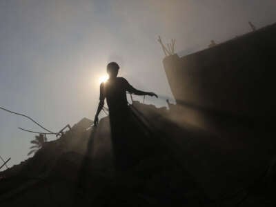 Silhouette of a Palestinian searching for his belongings after Israeli attack struck Khadija School, which also served as a field hospital in Deir al-Balah, Gaza, on July 27, 2024.