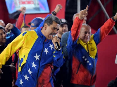 Nikolas Maduro delivers a speech into a microphone