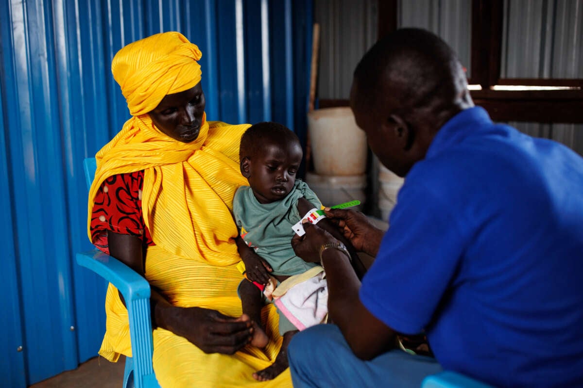 A young boy recovering from measles is bought into a clinic by his mother for mid-upper arm circumference measurements on November 29, 2023, in Rotriak, South Sudan. The young boy was found to have severe acute malnutrition and was referred to a medical center for treatment.