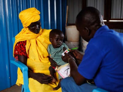 A young boy recovering from measles is bought into a clinic by his mother for mid-upper arm circumference measurements on November 29, 2023, in Rotriak, South Sudan. The young boy was found to have severe acute malnutrition and was referred to a medical center for treatment.