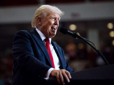 Donald Trump shouts into a microphone at a podium