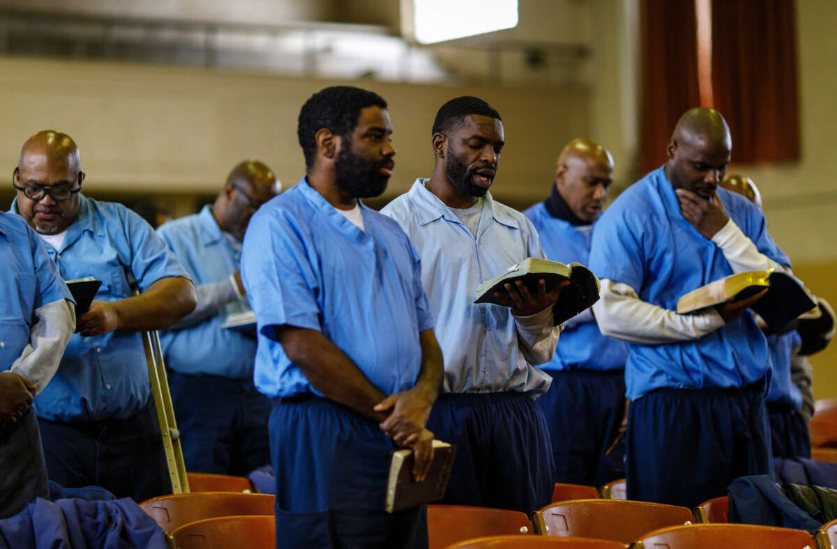 Inmates sing as Helen Sinclair, a 98-year-old volunteer prison chaplain known as Queen Mother, helps lead in a church service on February 10, 2019, at the Stateville Correctional Center in Illinois.