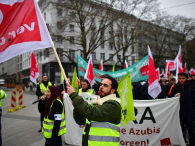 Striking public transport workers and activists from the Fridays For Future climate movement walk with flags during a protest on March 3, 2023 in Hanover, Germany.