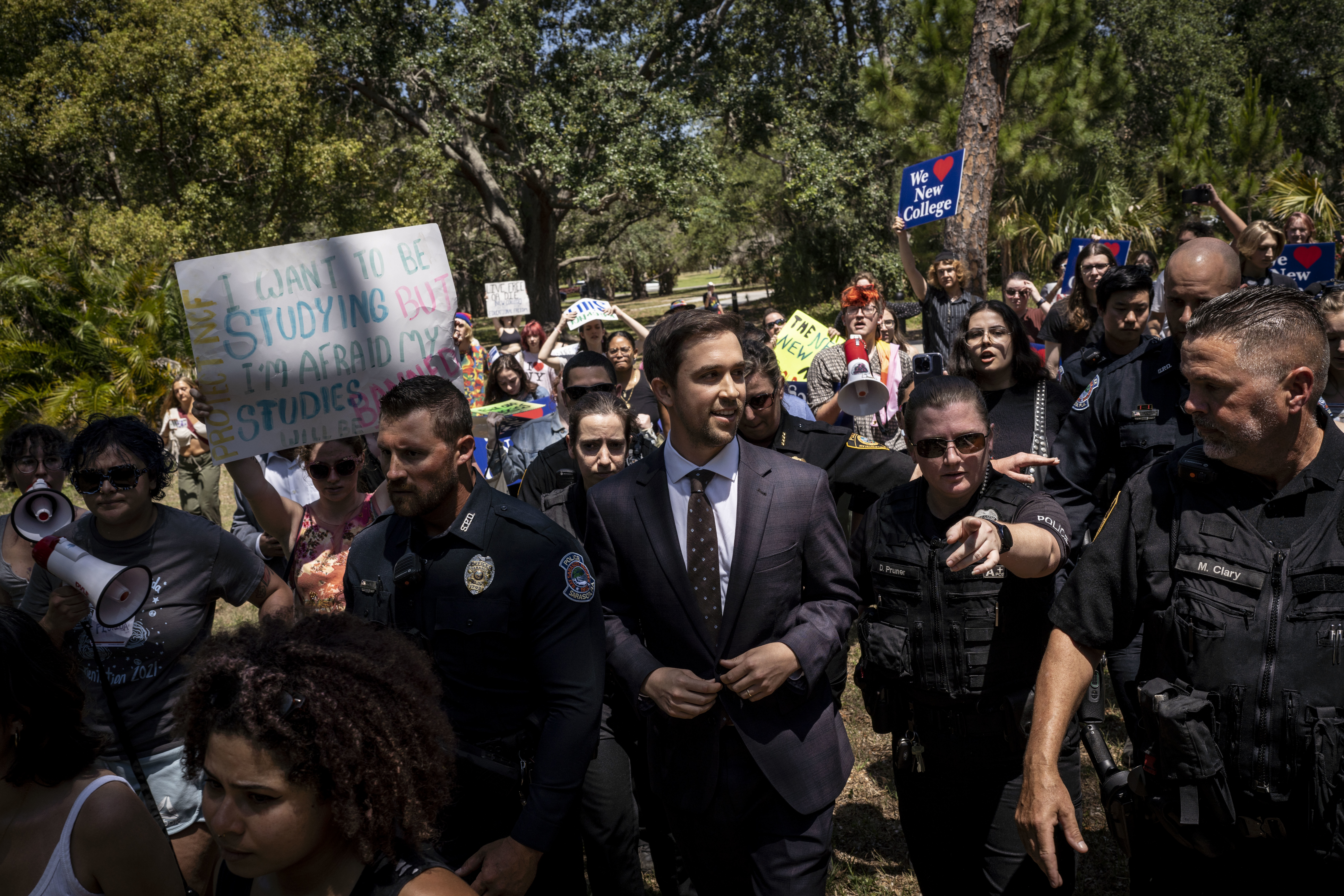 Christopher Rufo, a right wing activist and New College of Florida trustee, walks through protestors on his way out of a bill signing event featuring Florida Governor Ron DeSantis, who signed three education bills on the campus of New College of Florida in Sarasota, Florida, on Monday, May 15, 2023.