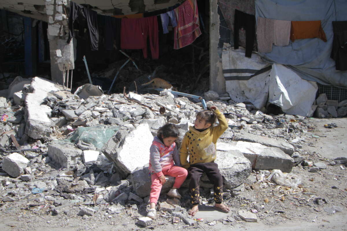 Palestinians children sitting in the rubble of a UN school in Gaza where they are taking shelter, on March 4, 2024.