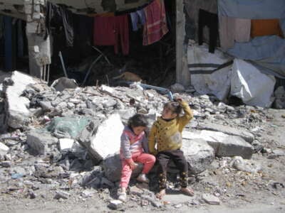 Palestinians children sitting in the rubble of a UN school in Gaza where they are taking shelter, on March 4, 2024.