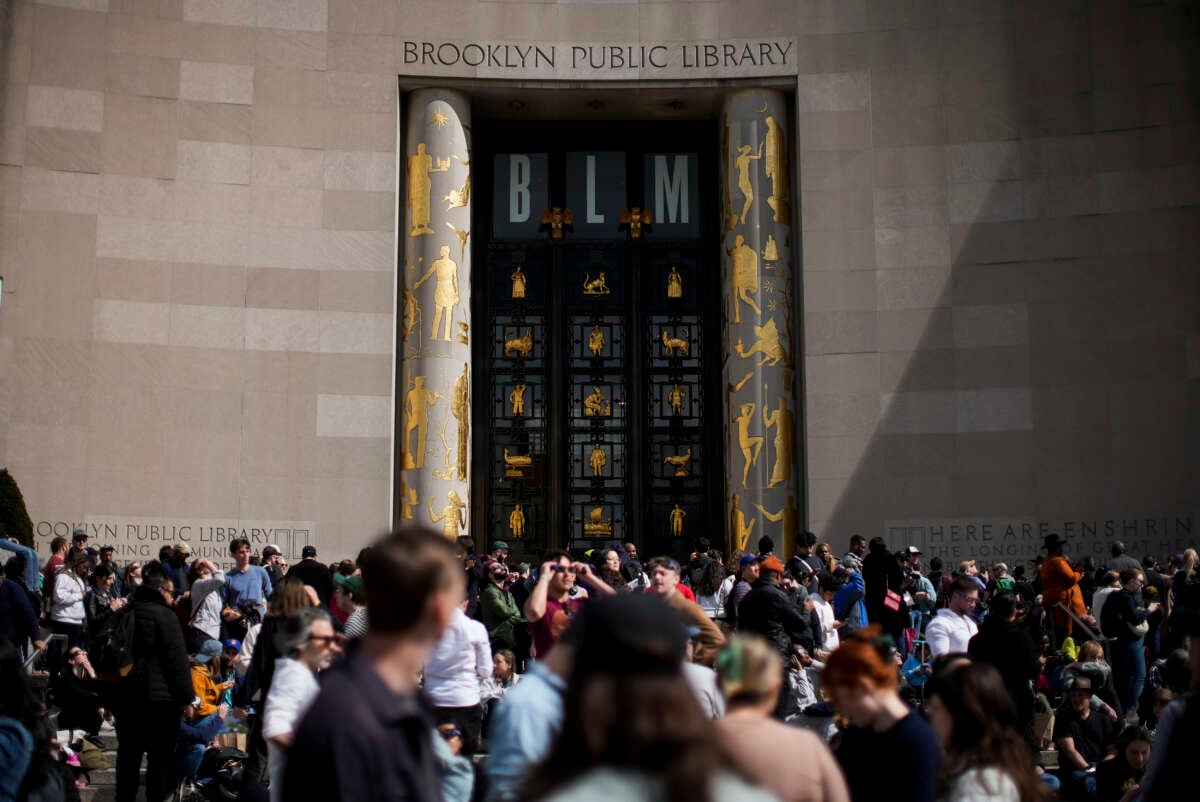 People gather to watch the partial solar eclipse from Brooklyn Public Library on April 8, 2024, in Brooklyn, New York.