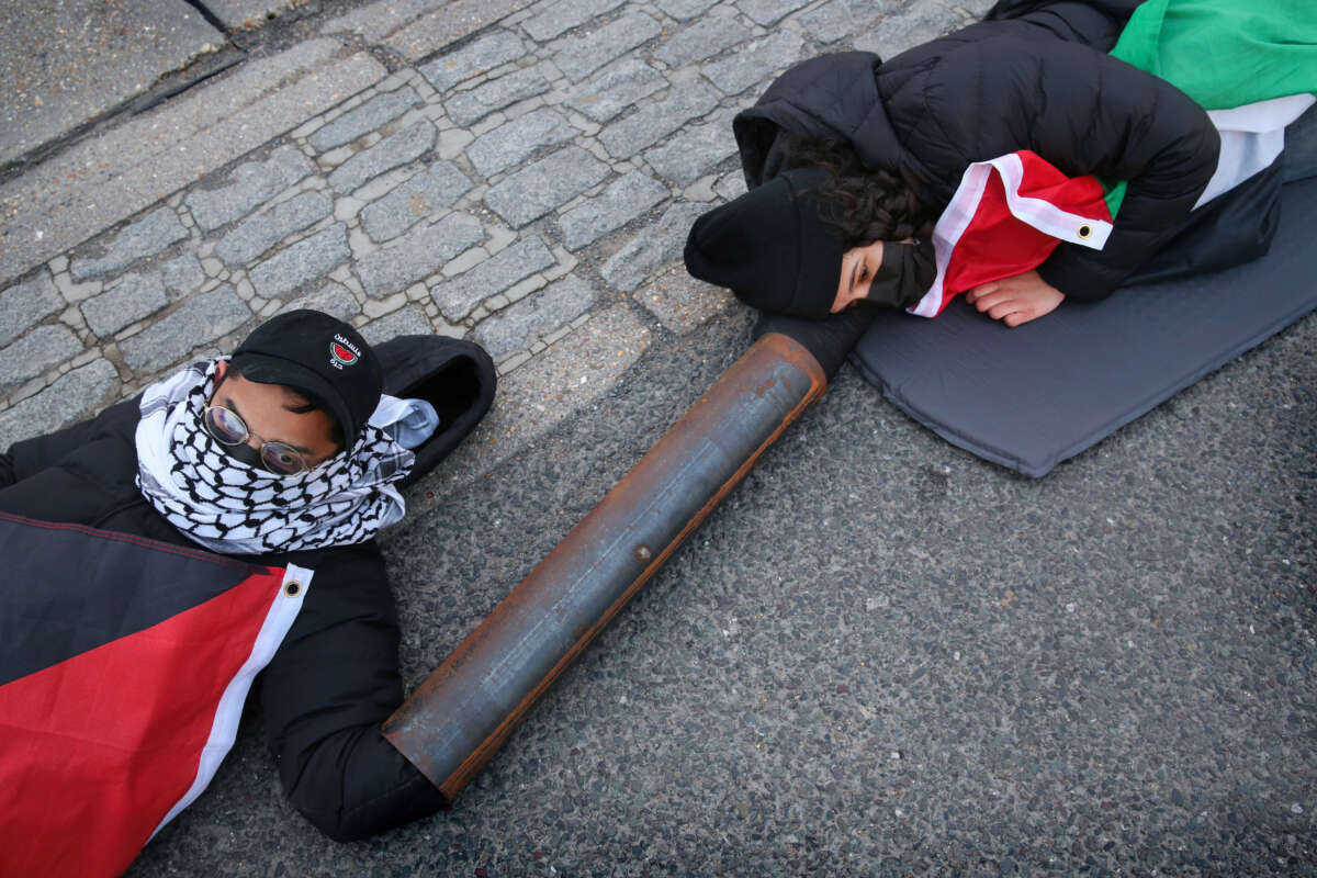 Activists from Palestine Action lock on and lay in the middle of an access road to Discovery Park, a business estate in Sandwich, U.K., on April 15, 2024. Instro Precision, a company owned by Israeli arms company Elbit Systems, operates a factory producing sights for Israeli sniper rifles. This action was part of the A15 coordinated global economic blockade for Palestine.