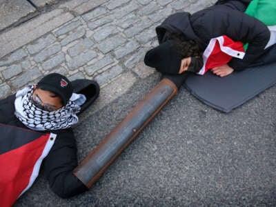 Activists from Palestine Action lock on and lay in the middle of an access road to Discovery Park, a business estate in Sandwich, U.K., on April 15, 2024. Instro Precision, a company owned by Israeli arms company Elbit Systems, operates a factory producing sights for Israeli sniper rifles. This action was part of the A15 coordinated global economic blockade for Palestine.