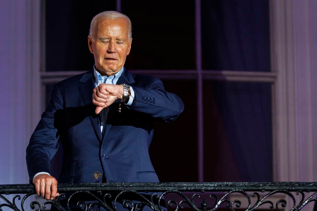 President Joe Biden checks his watch as he steps out onto the balcony of the White House to view the fireworks over the National Mall during a 4th of July event on the South Lawn of the White House, on July 4, 2024, in Washington, D.C.