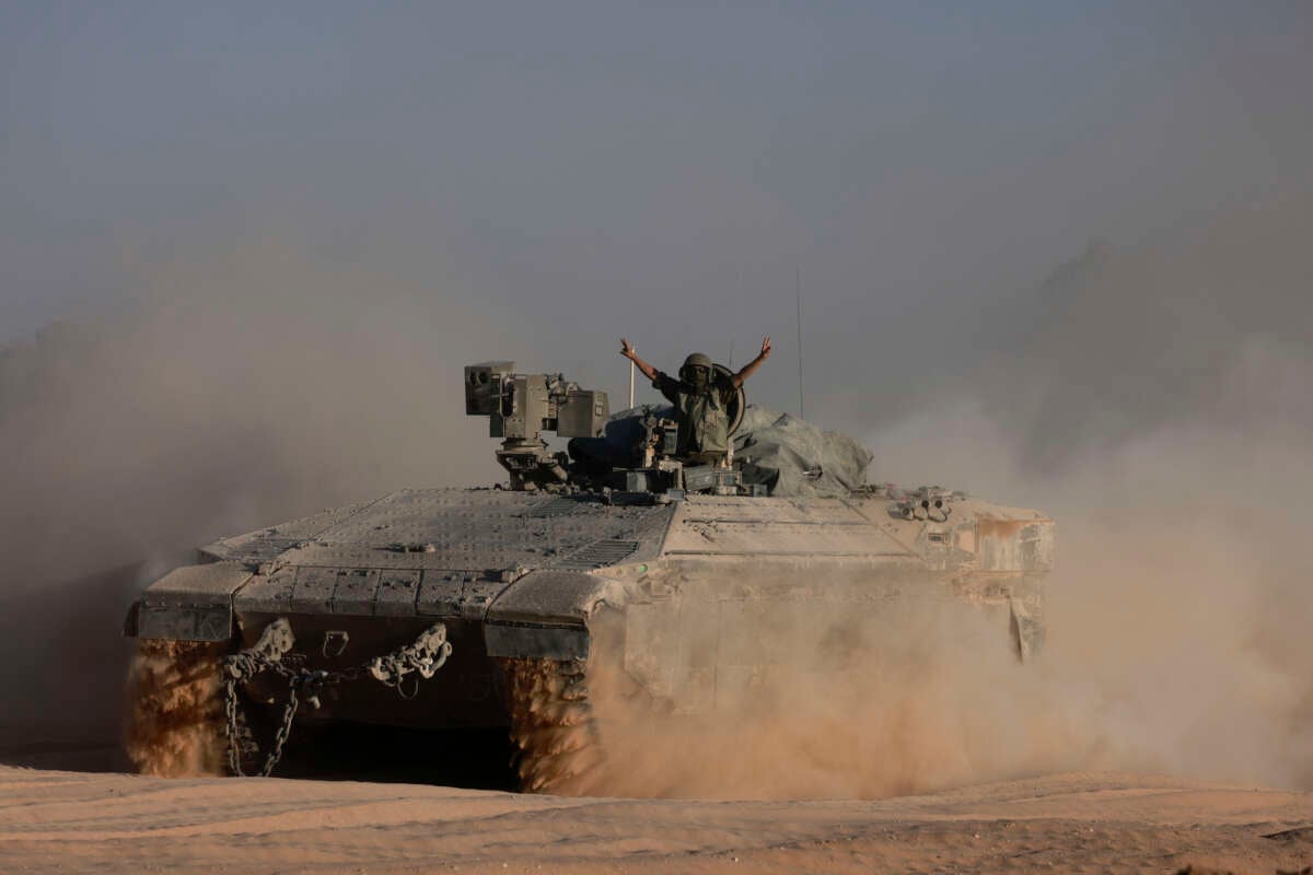 An Israeli soldier gestures from an armored personnel carrier on the border with the Gaza Strip on July 17, 2024.