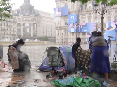 Unhoused Parisian family is caught in the rain.