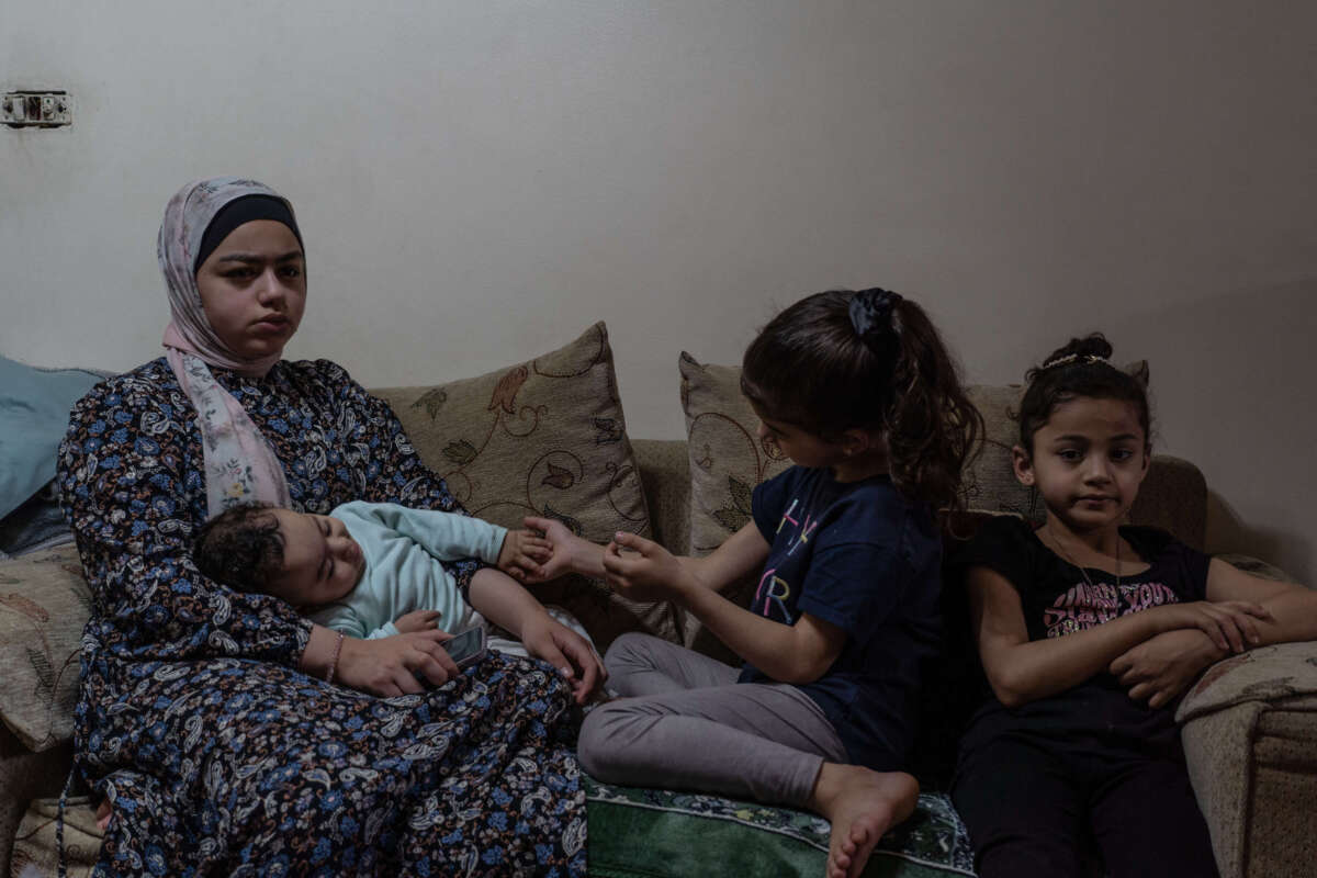 Jabr's children sit on a couch across from her, listening to her interview.