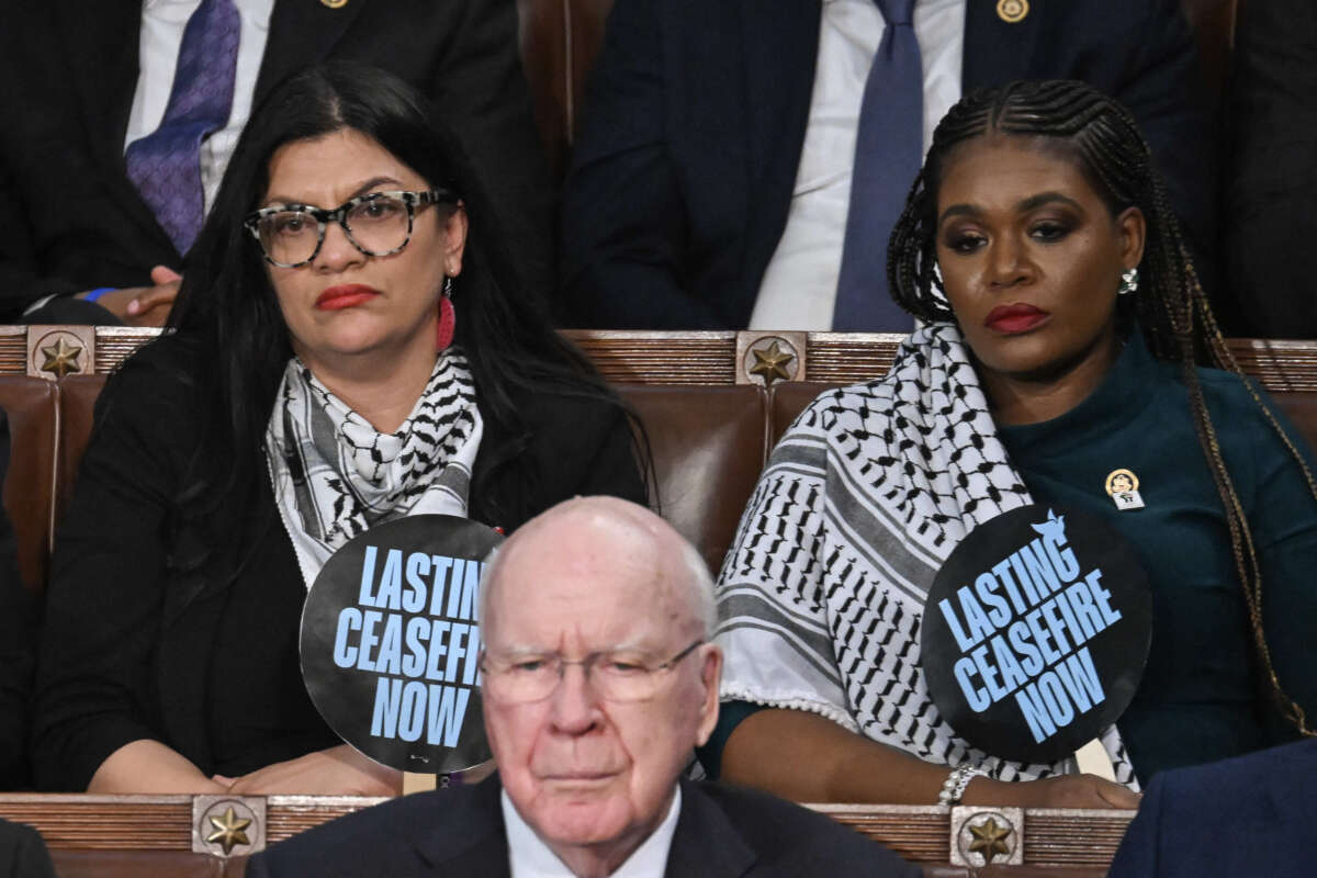 Reps. Rashida Tlaib and Cori Bush hold signs reading Lasting Ceasefire Now