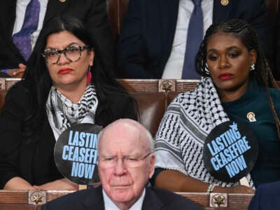 Reps. Rashida Tlaib and Cori Bush hold signs reading Lasting Ceasefire Now