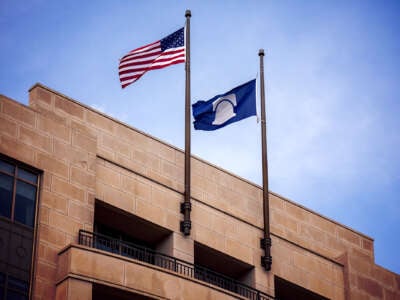 The flags of the United States and the Heritage Foundation fly side by side in front of the Heritage Foundation headquarters