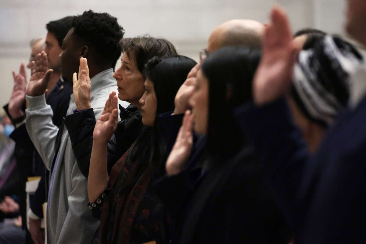 New U.S. citizens take the oath during a naturalization ceremony at the National Archives on December 15, 2023, in Washington, D.C.