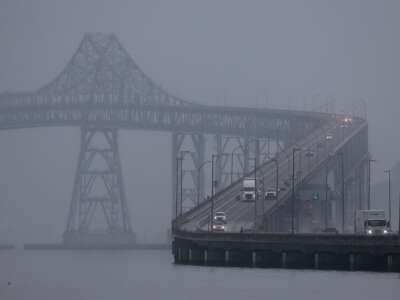 cars drive through either fog or smog on an overpass